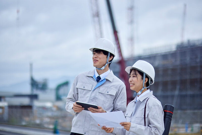 ヘルメットを着用し現場で確認する社員たち