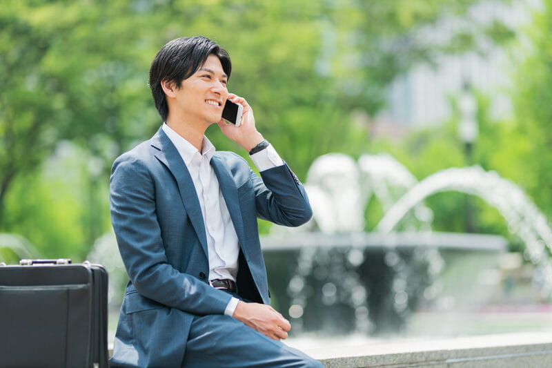 携帯電話で話す社員