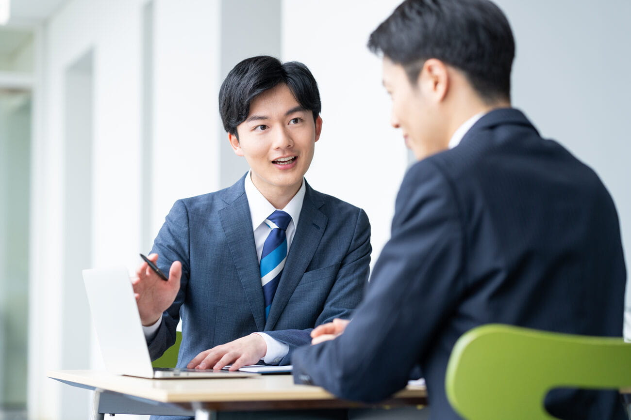 中小企業の経営者と打ち合わせをする社員