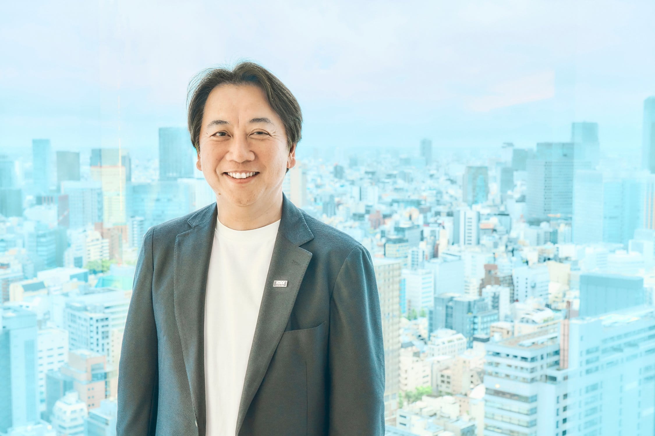都市を背景に佇む代表取締役社長 落合孝之