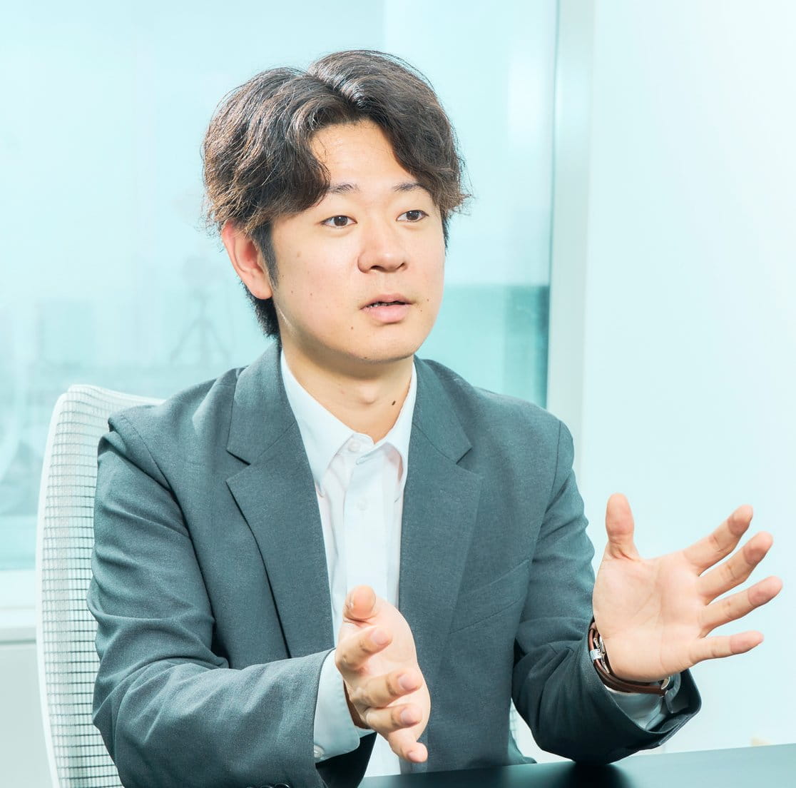 手ぶりを交えて仕事について語る佐藤さん
