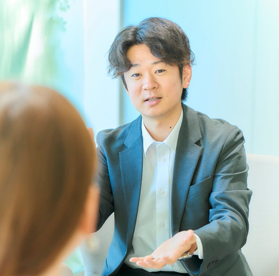お客さまに身振りを交えて説明する佐藤さん